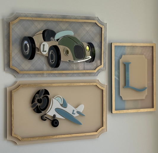 Three framed decorative items on a wall, including a car and airplane design.