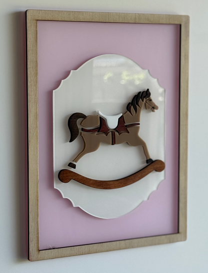 Wooden rocking horse in a decorative frame on a light pink background