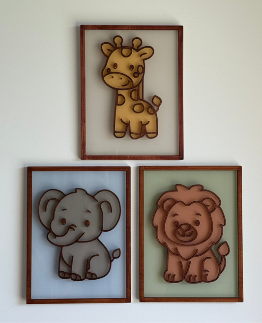 Three framed illustrations of a giraffe, elephant, and lion on a white wall.