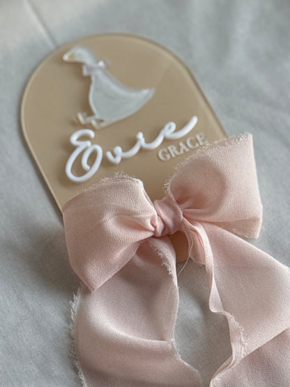 Baby sandal with a pink bow on a light background