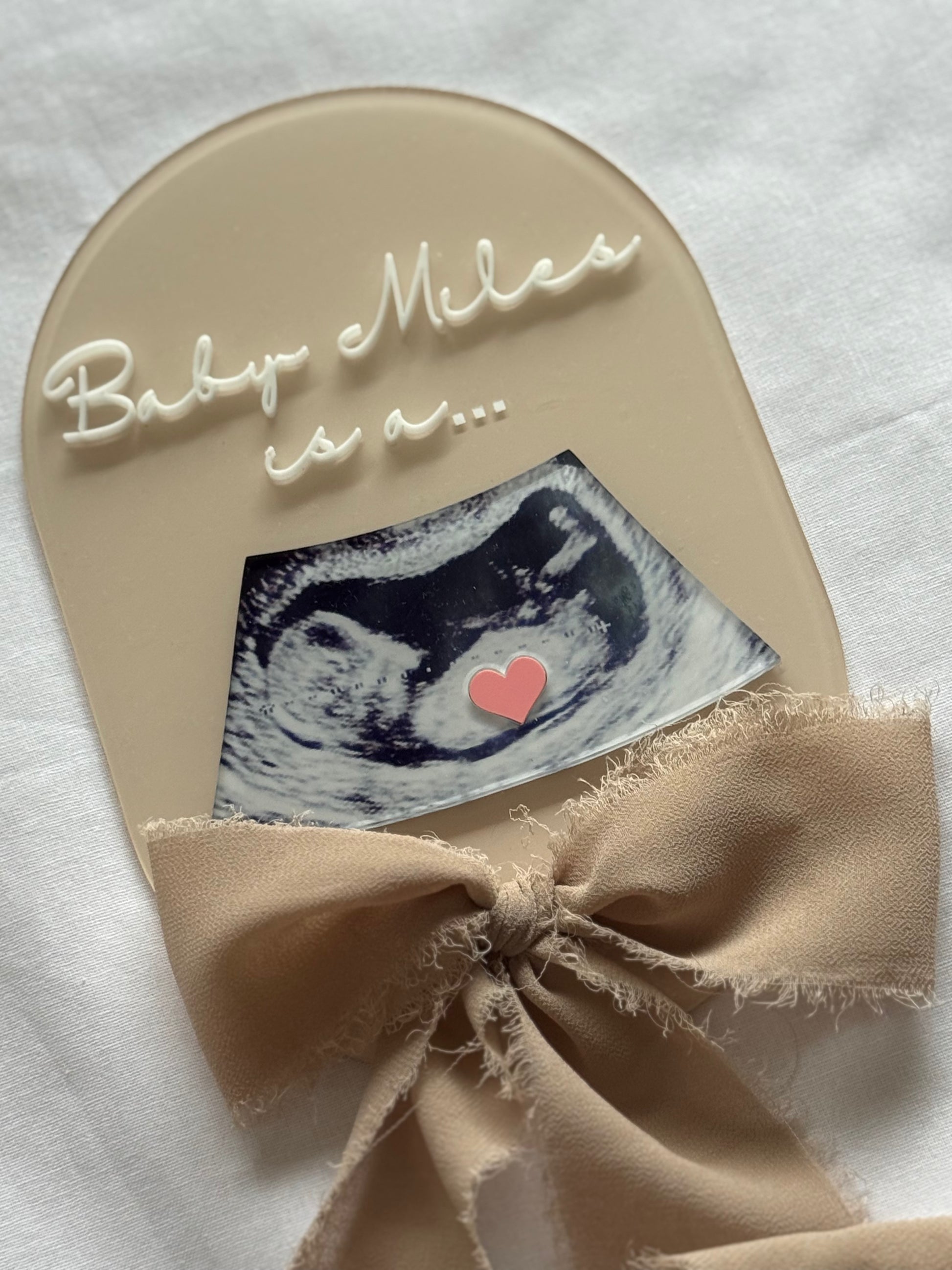 Baby shower card with ultrasound photo and bow on a white background