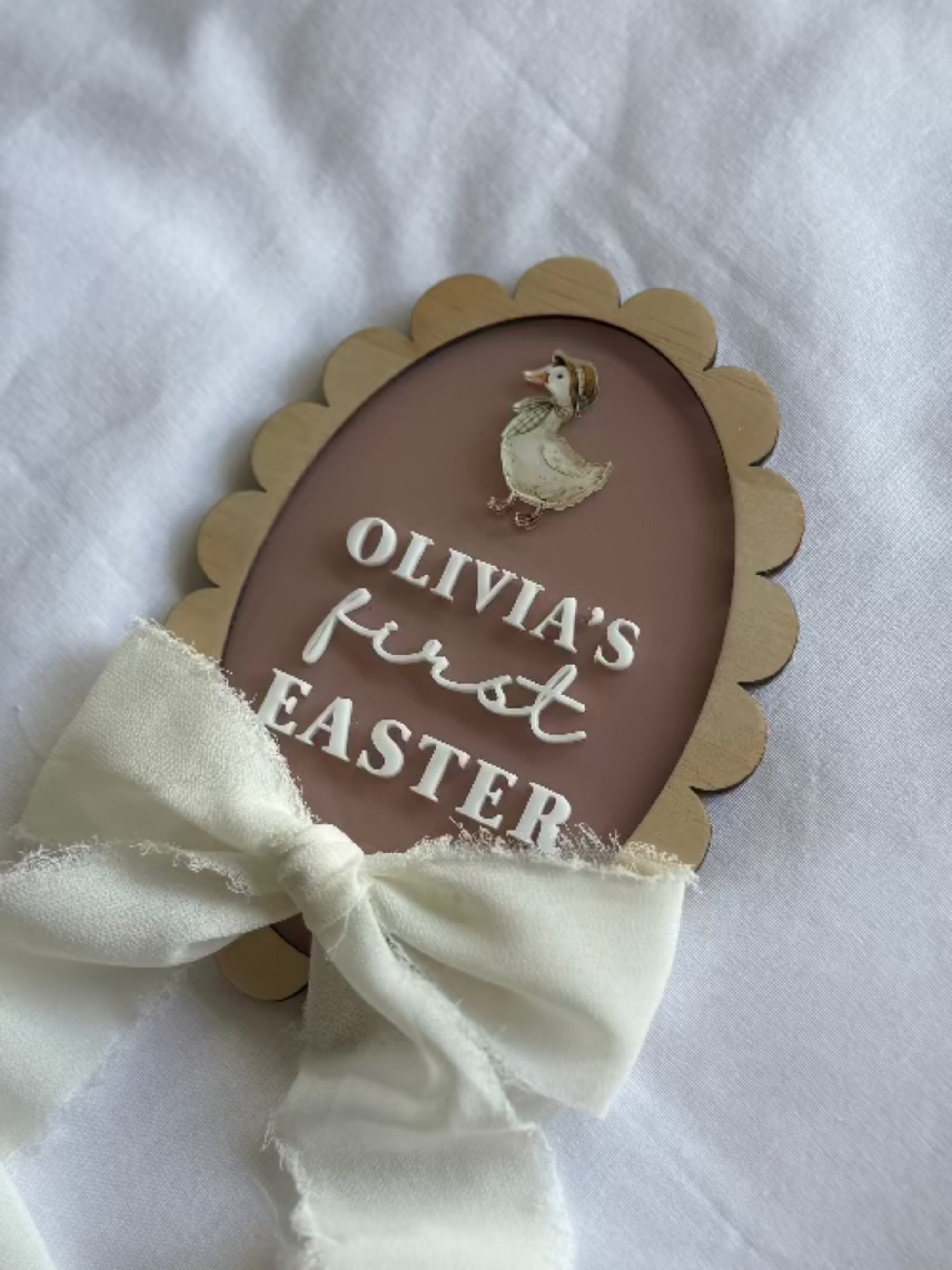 Decorative egg-shaped sign with Text and a duck illustration on a white background.