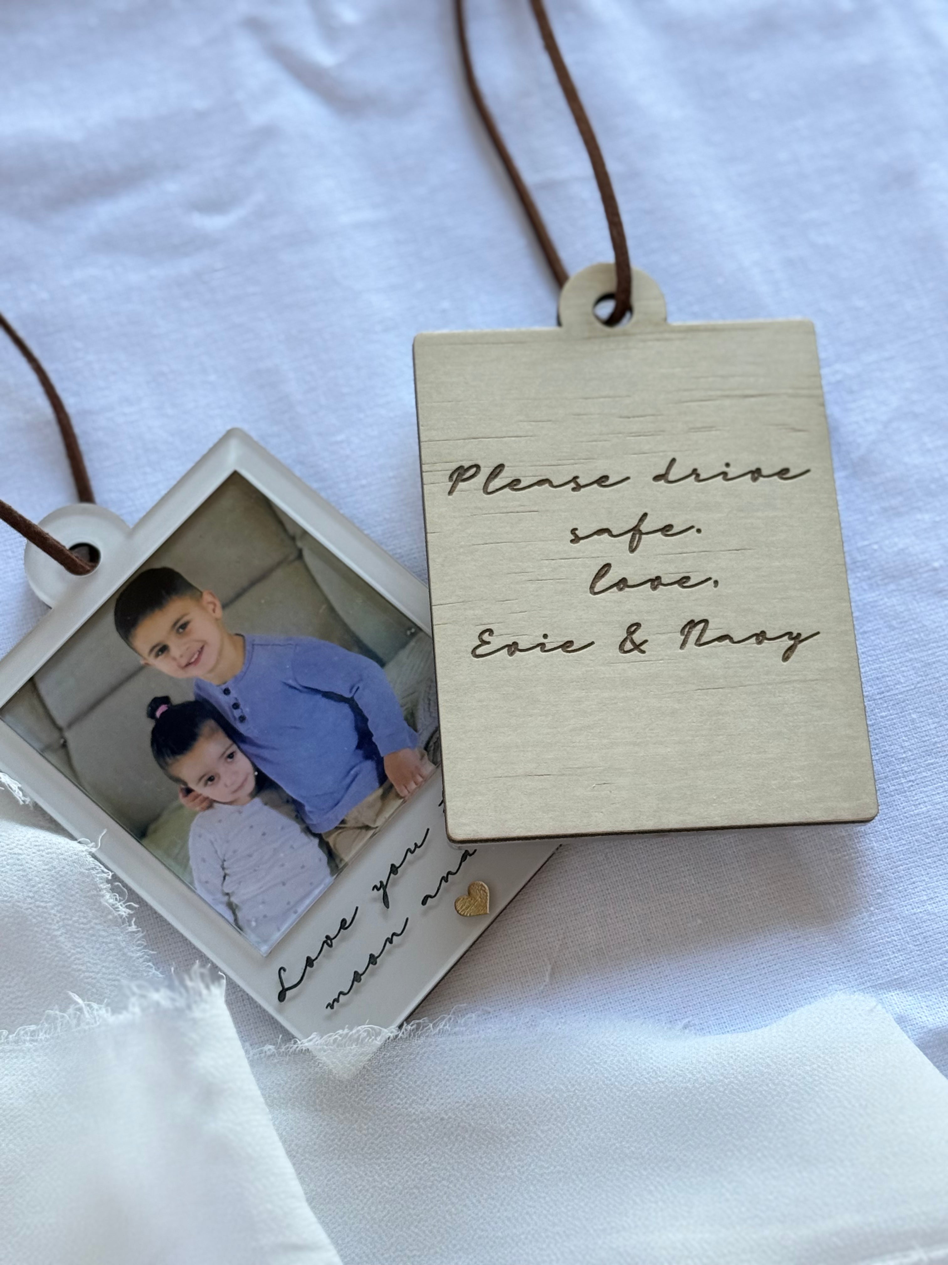 Personalized photo tag with children's photo and engraved message on a white fabric background